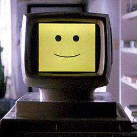 A 1970s computer monitor displaying a yellow smiley face