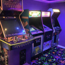 A row of multicolored arcade cabinets in an arcade