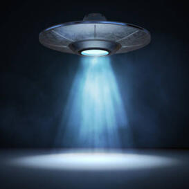 A UFO hovering with a tractor beam coming out of the bottom of it