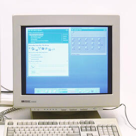 A 1990s-era computer monitor displaying a blue screen with a keyboard sitting in front of it